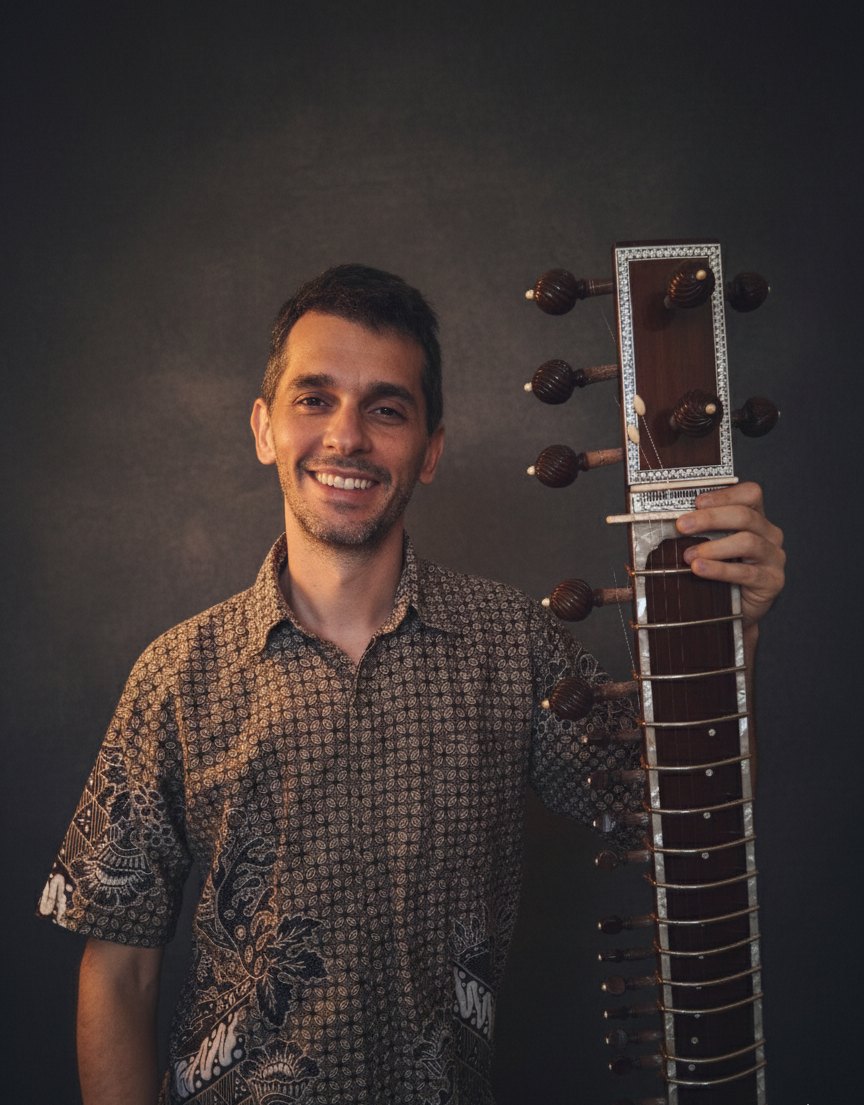 João holding a sitar